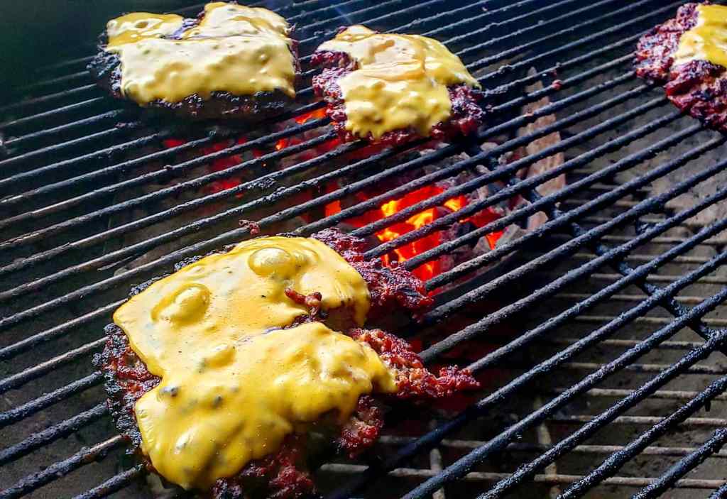 Grilling cheeseburgers, featuring bubbly cheese