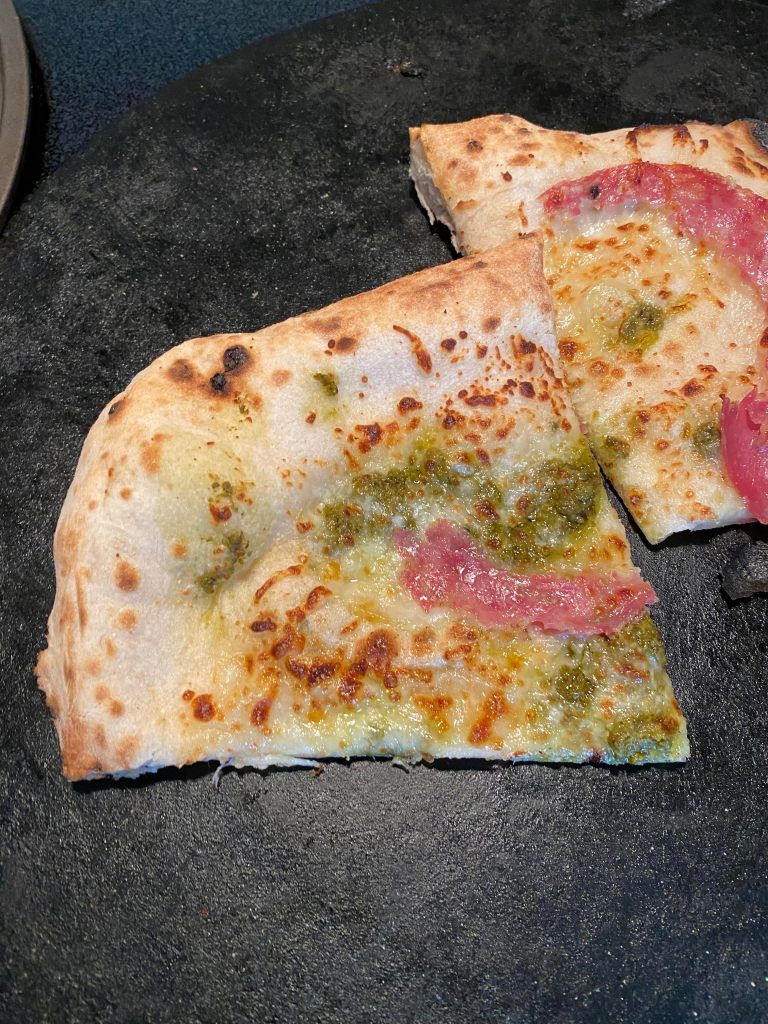 A salami pizza with a pesto base that was cooked in the Stoke Pizza Oven